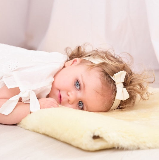 Young child lying on a genuine sheepskin baby rug